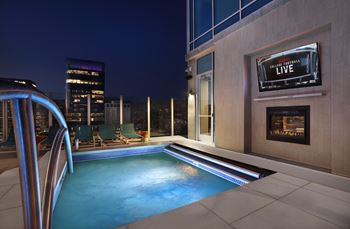 Rooftop pool with fireplace and outdoor tv